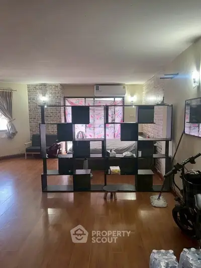 Spacious living room with wooden flooring and modern shelving unit