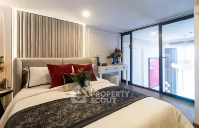 Luxurious bedroom with elegant decor and large glass doors leading to a balcony, perfect for relaxation.