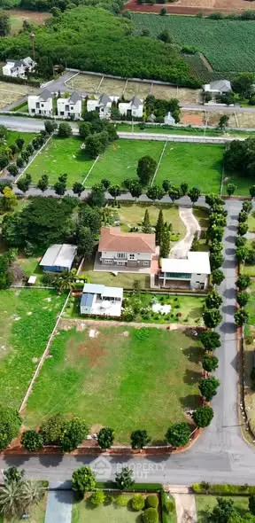 Aerial view of a luxurious estate with lush greenery and spacious surroundings.