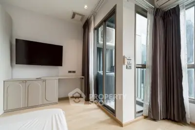 Modern bedroom with large TV and balcony access in a stylish apartment