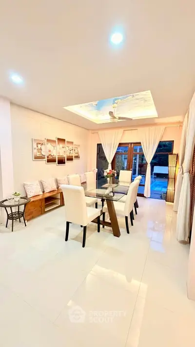 Elegant dining room with glass table, plush chairs, and ambient lighting in a modern home.