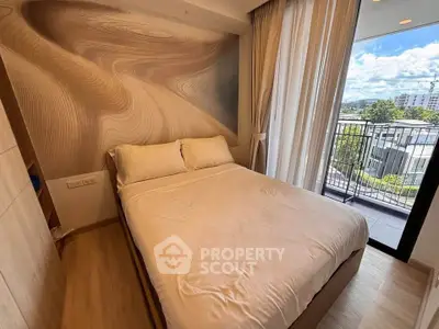Cozy bedroom with modern decor and balcony view in a stylish apartment.