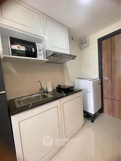 Modern compact kitchen with sleek appliances and stylish cabinetry