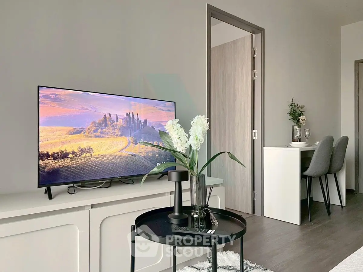 Modern living room with sleek furniture and large TV, perfect for relaxation and entertainment.
