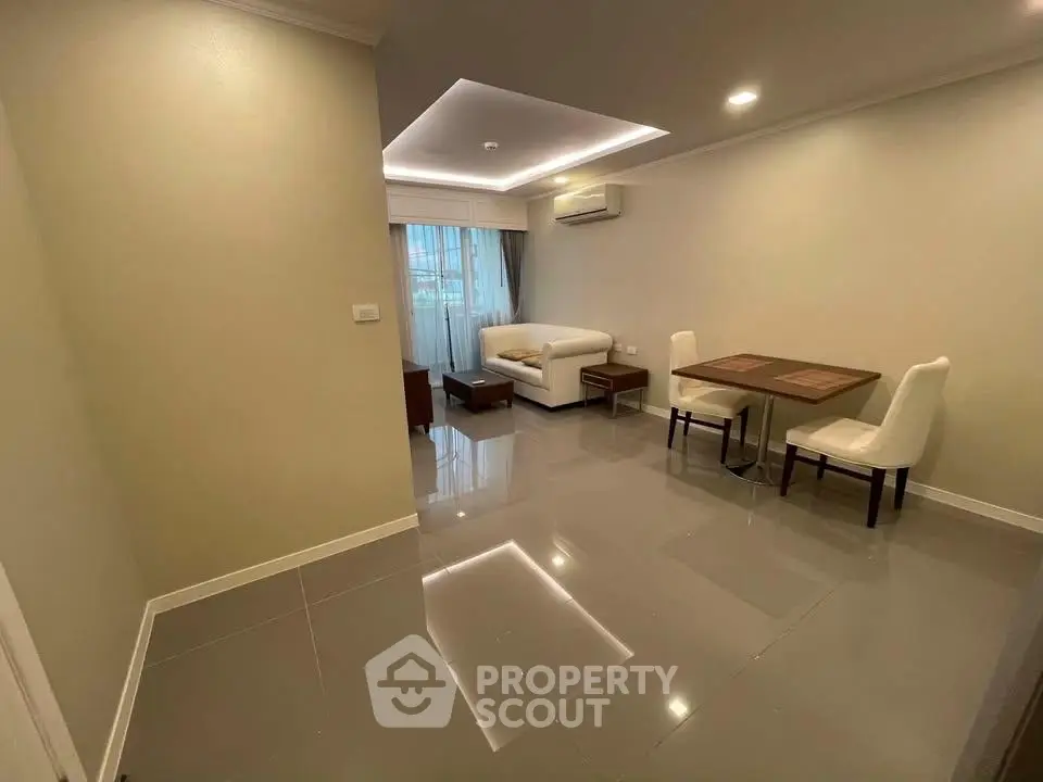 Spacious modern living room with elegant furniture and glossy tiled flooring.