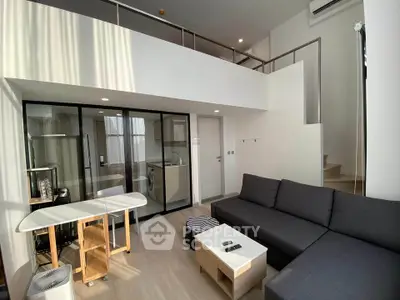 Modern loft apartment with mezzanine, sleek furniture, and ample natural light.