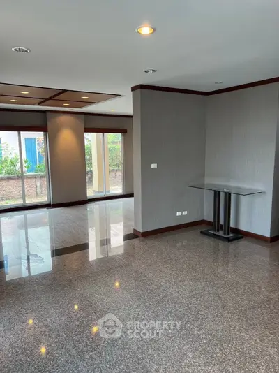 Spacious modern living room with glossy tile flooring and large windows