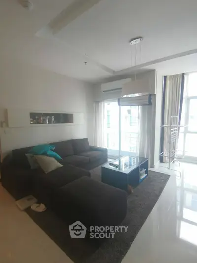 Spacious living room with modern sofa and large windows offering natural light