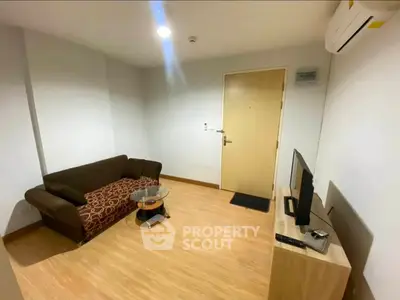 Cozy living room with modern sofa and TV setup, perfect for relaxation.