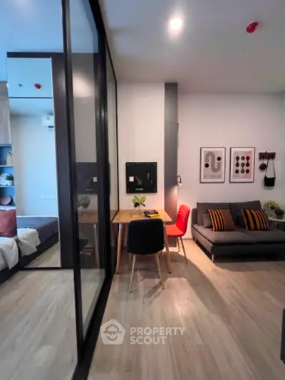 Modern studio apartment with stylish decor, featuring a cozy living area and a sleek glass partition.