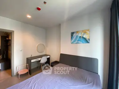 Modern bedroom with stylish decor and workspace, ideal for urban living.