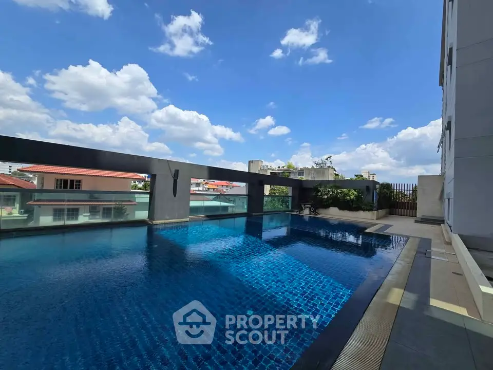 Luxurious rooftop pool with stunning city views and clear blue skies, perfect for relaxation and leisure.