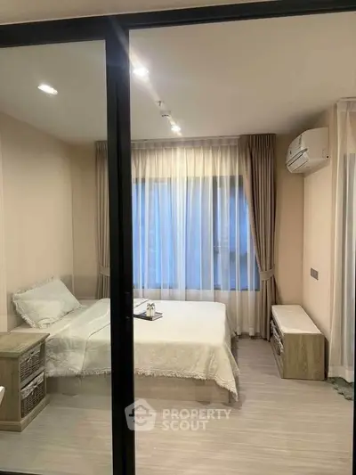 Modern bedroom with large window, elegant curtains, and sleek air conditioning unit.