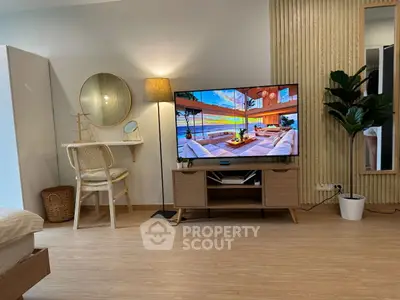 Modern living room with stylish decor and large TV, perfect for relaxation.