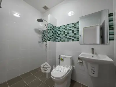 Modern bathroom with sleek tiles and contemporary fixtures in a real estate property.