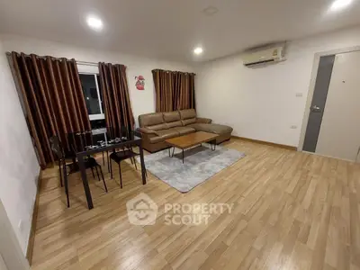 Spacious living room with modern furniture and wooden flooring, perfect for relaxation and entertainment.