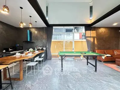Spacious modern living room with pool table and open kitchen layout