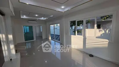 Spacious modern living room with large windows and glossy tiled floors, perfect for natural light lovers.