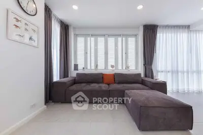 Modern living room with stylish brown sofa and large windows