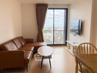 Modern living room with leather sofa and city view from large window.