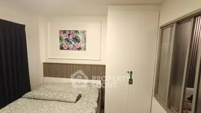 Cozy bedroom with modern decor and floral artwork, featuring a comfortable bed and ample storage space.