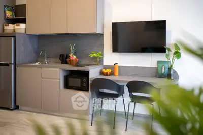 Modern kitchen with sleek cabinetry, built-in microwave, and stylish seating area.