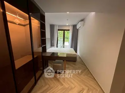 Modern bedroom with large window and stylish wooden flooring