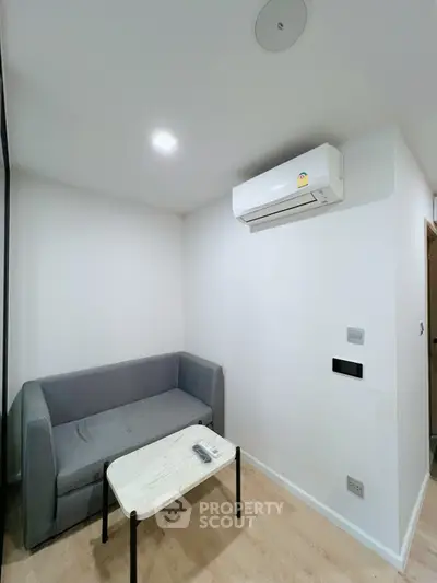 Modern minimalist living room with gray sofa and air conditioning