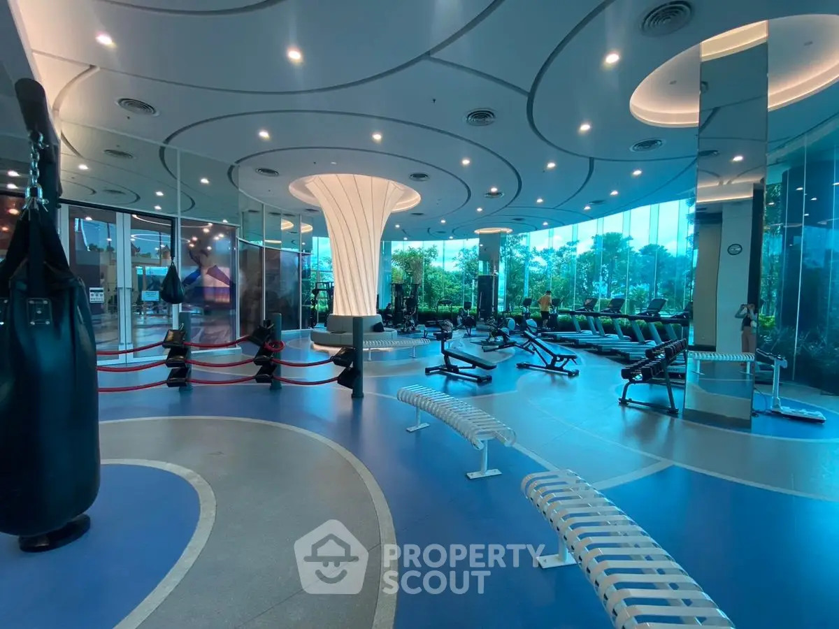 Luxurious modern gym with panoramic windows and state-of-the-art equipment in a high-end real estate property.