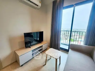 Modern living room with balcony view, featuring sleek furniture and natural light.
