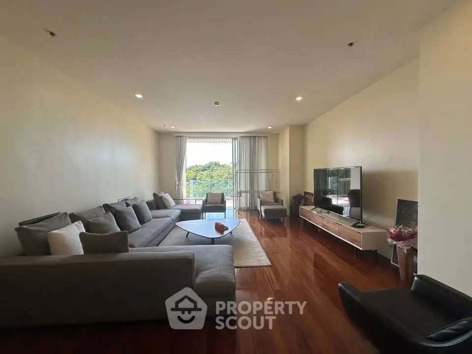 Spacious living room with modern furniture and large windows offering a scenic view.