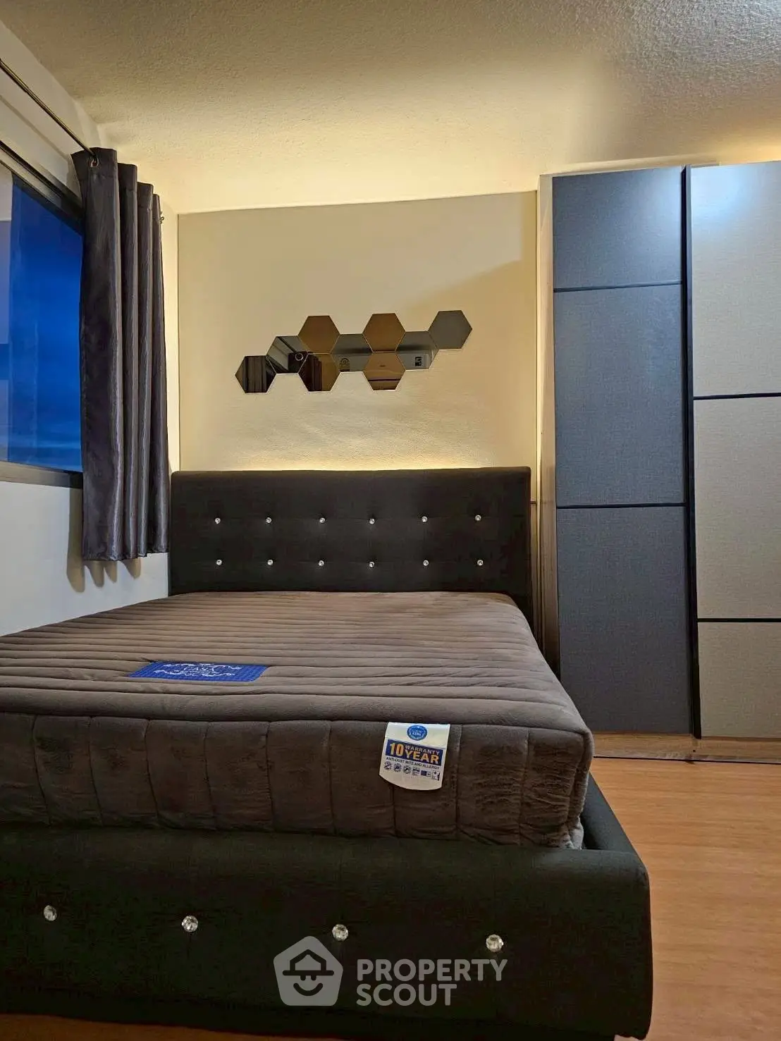 Modern bedroom with stylish bed and mirrored wall decor in a cozy apartment.