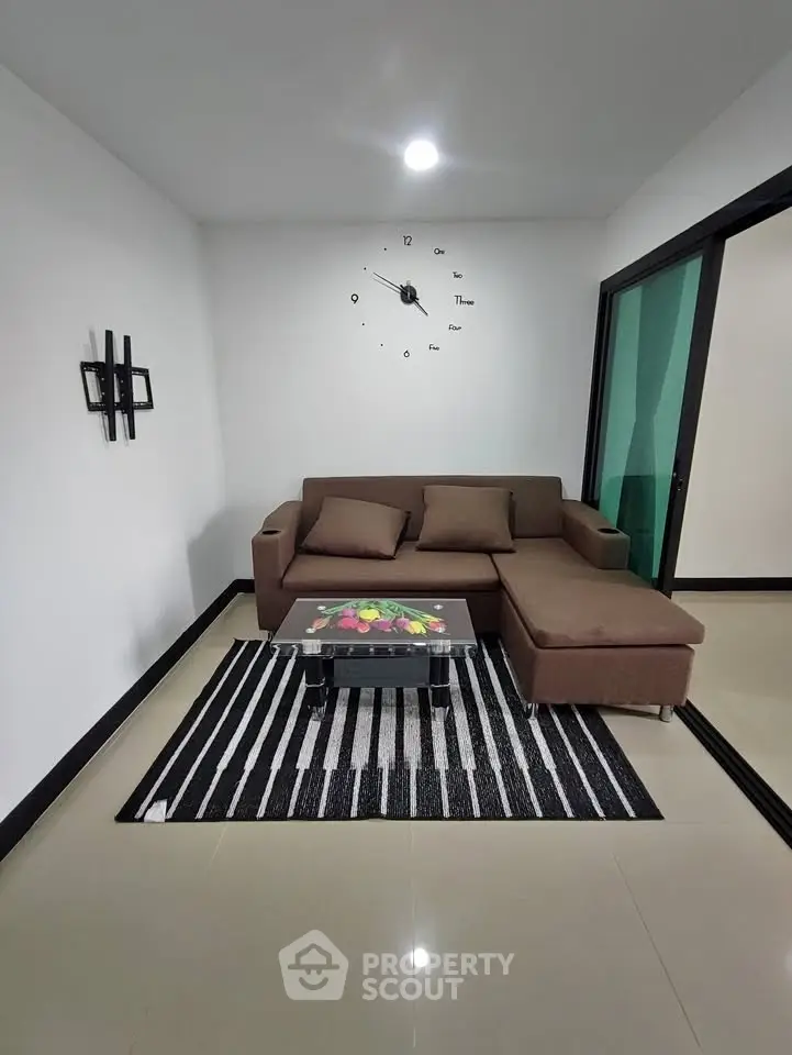 Modern living room with stylish brown sofa and wall clock, featuring sleek design and contemporary decor.