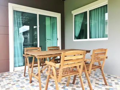 Charming patio with wooden furniture and sliding glass doors, perfect for outdoor relaxation.