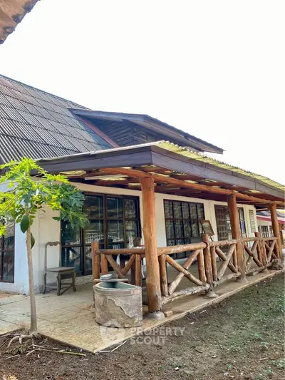 Charming rustic house with wooden porch and lush garden, perfect for nature lovers.