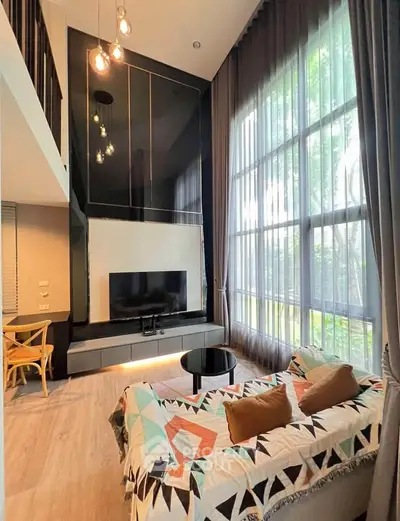 Stunning modern living room with high ceilings and large windows offering natural light and garden views.
