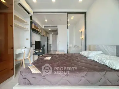Modern bedroom with cozy bed, study desk, and sleek design in a stylish apartment.