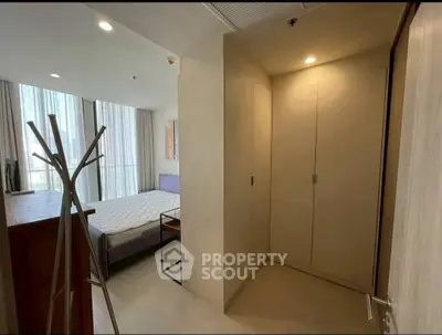 Modern bedroom with natural light and minimalist design, featuring a cozy bed and sleek wardrobe.