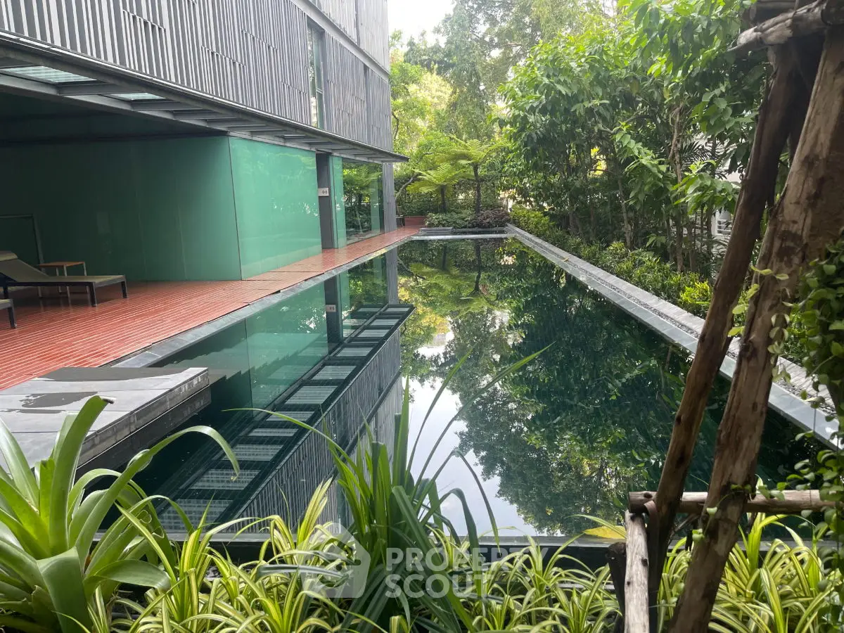 Luxurious modern pool area with lush greenery and sleek architectural design