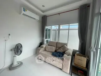Cozy living room with air conditioning and natural light, perfect for relaxation.