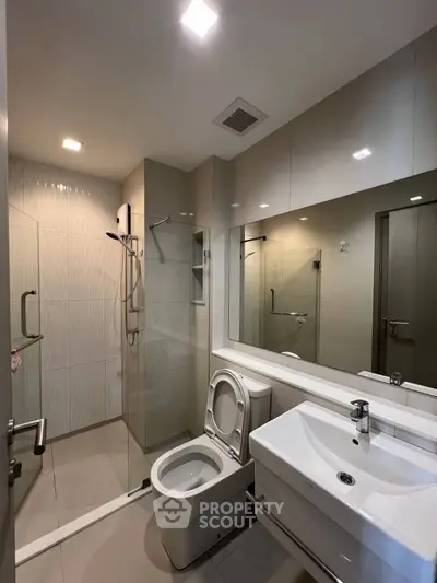 Modern bathroom with glass shower and sleek fixtures in a contemporary apartment.