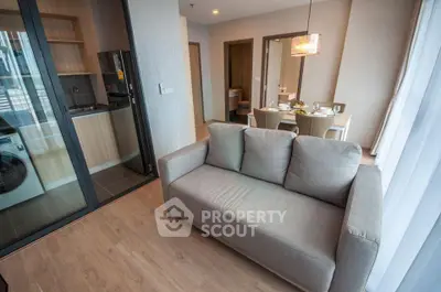 Modern open-plan living room with cozy sofa and stylish dining area in a contemporary apartment.