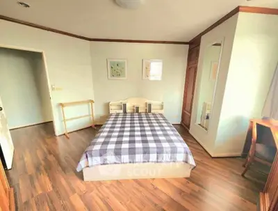 Spacious bedroom with wooden flooring and stylish decor
