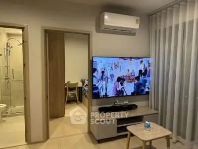 Modern living room with TV, air conditioning, and view into bathroom and bedroom.