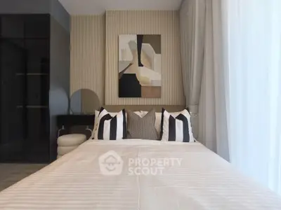 Modern bedroom with stylish decor and abstract art, featuring a cozy bed and elegant curtains.