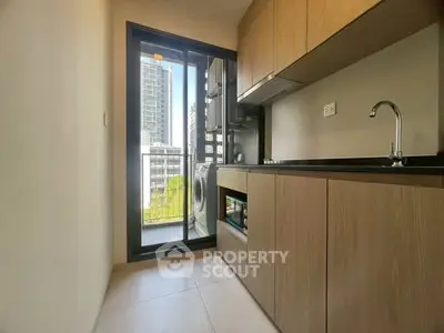 Modern kitchen with sleek cabinets and city view from balcony