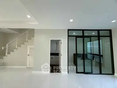 Modern interior with sleek staircase and glass partition in spacious living area