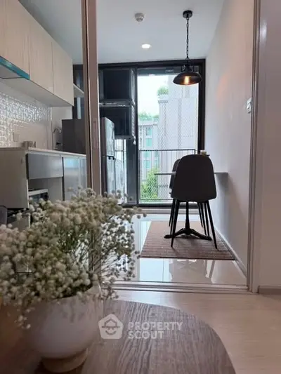 Modern kitchen with open layout and dining area, featuring sleek appliances and stylish decor.
