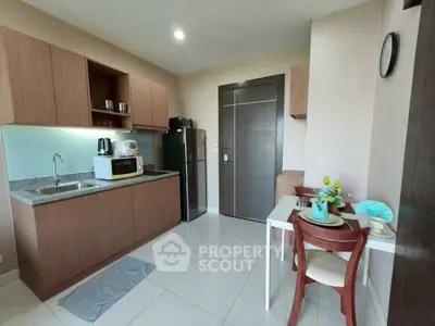 Modern kitchen with dining area, featuring sleek cabinets and appliances.