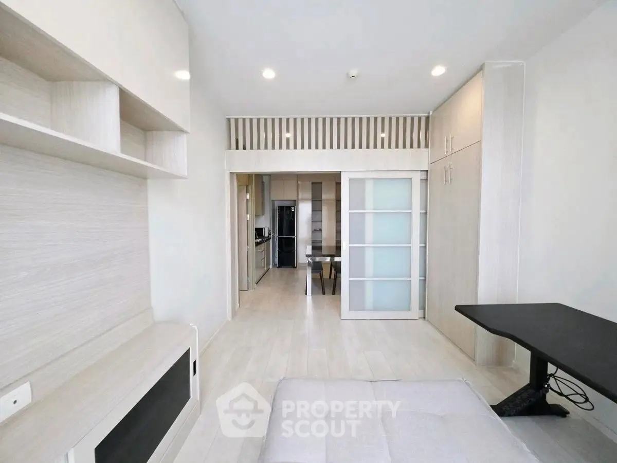 Modern minimalist living space with open kitchen and sleek design.